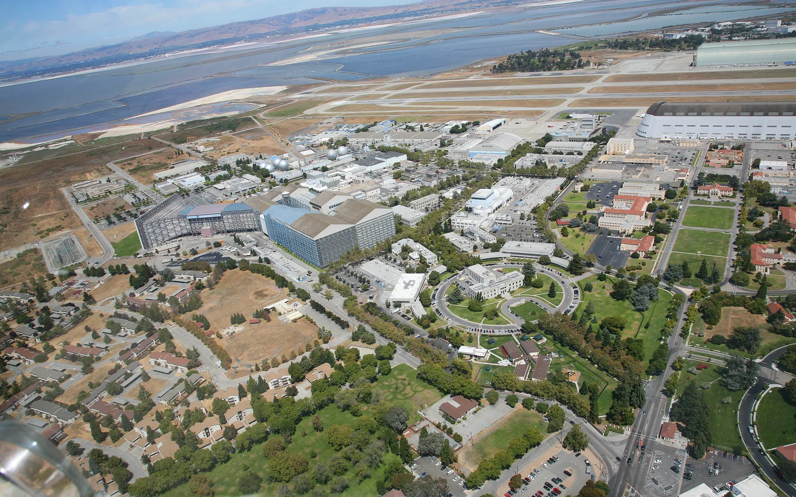 An aerial photograph of NASA Ames Research Center at Moffett Field near Palo Alto, showing aeronautical research facilities and laboratory buildings